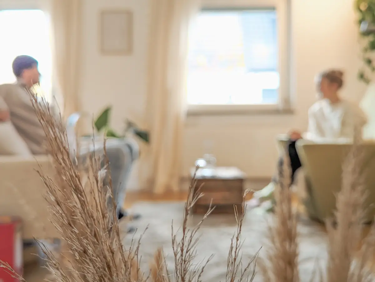Psychotherapie-Sitzung in hellem Raum mit zwei Personen bei entspannter Atmosphäre.
